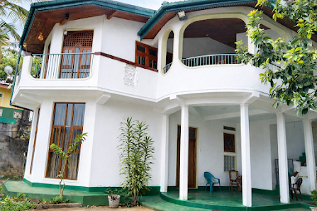 The white two-storey V6 Nest house with its balcony and front garden